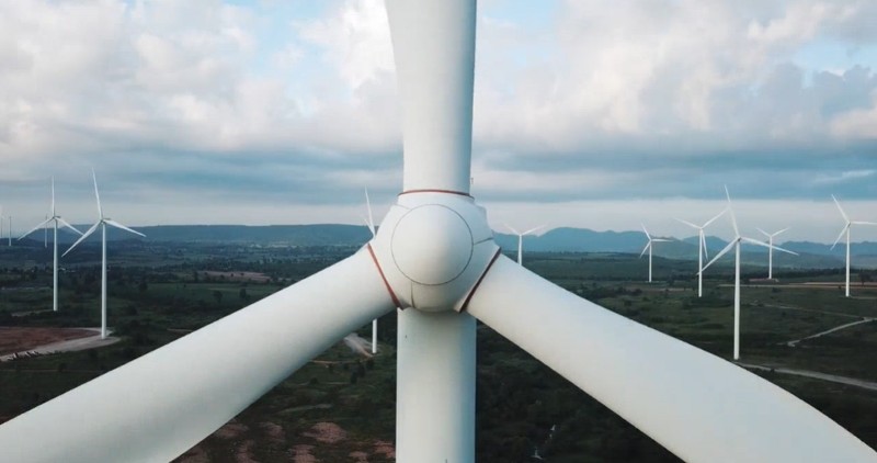 Large wind turbines pictured in a field