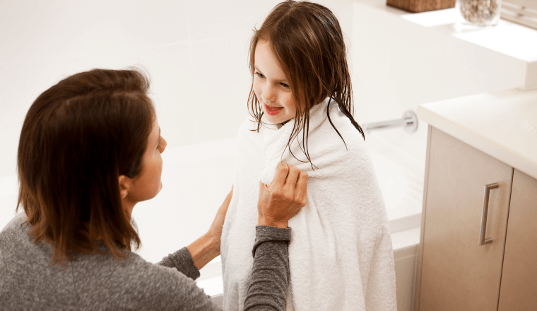 Mum wrapping towel around daughter